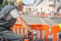 Old man, an amateur cyclist, observing professional cyclistes with their race bicycle passing by in front of him with a speed blur