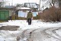 An old man approaches a stripped-down belly hung on a rope. City Pioneerskij, Kaliningrad region