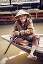 Old man on a boat in river, Vietnam.