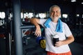 Old man with bottle of water and towel in gym Royalty Free Stock Photo