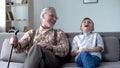 Old man and boy laughing genuinely, joking, valuable fun moments together Royalty Free Stock Photo