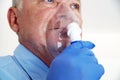 Old man breathing through an inhaler, portrait close-up Royalty Free Stock Photo