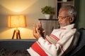 Old man busy using mobile phone at home while sleeping on sofa - concept of senior people using technology, internet and Royalty Free Stock Photo