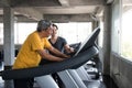 Old man cardio walking on treadmill with trainer Royalty Free Stock Photo