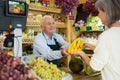 Old man cashier serving customer in greengrocer Royalty Free Stock Photo