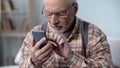 Old man cautiously using smartphone, learning apps and new technologies, closeup Royalty Free Stock Photo