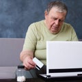 Old man checking medications prescription online