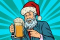 Old man in a Christmas cap with a mug of foam beer Royalty Free Stock Photo