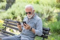 Old man compare two smartphones Royalty Free Stock Photo