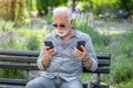 Old man compare two smartphones Royalty Free Stock Photo