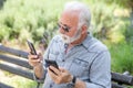 Old man compare two smartphones Royalty Free Stock Photo