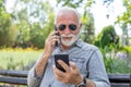 Old man compare two smartphones Royalty Free Stock Photo