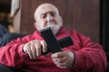 elderly man confused with tv remote controls Royalty Free Stock Photo