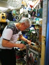 20/3/2019 old man copying a key with Duplicate machine in a crowded small shop, Locksmith theme. Blank keys for cutting. door