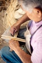 Old man crafter making product with wicker made it from willow tree