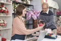 Old man customer payment by scanning phone application to female florist owner. Royalty Free Stock Photo