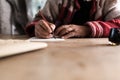 Old man with dirty hands writing a letter using a nib pen and in