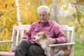 Old man with dog on bench in park Royalty Free Stock Photo