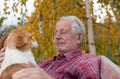 Old man with dog on bench in park Royalty Free Stock Photo