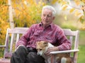 Old man with dog on bench in park Royalty Free Stock Photo