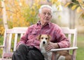 Old man with dog on bench in park Royalty Free Stock Photo