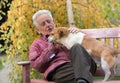 Old man with dog on bench in park Royalty Free Stock Photo