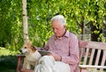 Old man with dog and tablet in garden Royalty Free Stock Photo