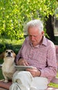 Old man with dog and tablet in garden Royalty Free Stock Photo
