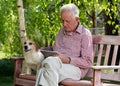 Old man with dog and tablet in garden Royalty Free Stock Photo