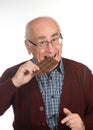 Old man eating chocolate Royalty Free Stock Photo