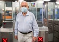 Old man in face mask at entrance to metro station