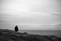 An old man is fishing near the beach in the morning