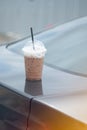 Old man forget iced Mocha coffee on front roof of car Royalty Free Stock Photo