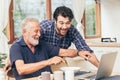 Old man fun smile happy to looking at laptop with son. using communication technology for family happiness elder home care to Royalty Free Stock Photo