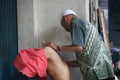 Old man giving a traditional indonesian massage to a young men Royalty Free Stock Photo