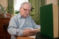 Old man in glasses reading a books in the room Royalty Free Stock Photo