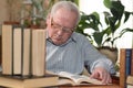 Old man in glasses reading a books in the room Royalty Free Stock Photo