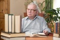 Old man in glasses reading a books in the room Royalty Free Stock Photo