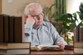 Old man in glasses reading a books in the room Royalty Free Stock Photo