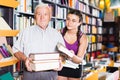 Old man with granddaughter are showing books