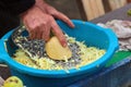 Old man grates a squash. Hands hold grater and vegetable