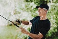 Old Man with Gray Hair Fishing on River in Summer.