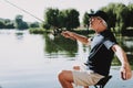 Old Man with Gray Hair Fishing on River in Summer.