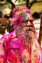 Old man with grey beard covered in Holi paint colors Royalty Free Stock Photo