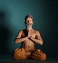 Old man with grey beard doing yoga, pilates, fitness training, stretching exercise, asana or balance workout on floor Royalty Free Stock Photo