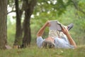 old man with grey hair lying on grasses,smiling and reading a book in the park Royalty Free Stock Photo