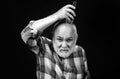 Old man with hair clipper isolated on black. Bald man hairclipper, Mature baldness and hair loss concept.