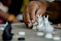 Old man hand moving Thai Chess Figure on Wood Checkerboard