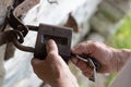 Old man hands holding metal vintage lock and key to open close old wooden door Royalty Free Stock Photo