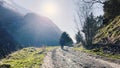 Old man hiking in the mountains. Stones, trees. Wide view. Sunset, sunrise.